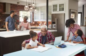 Children Doing Homework In Busy Multi Generation Family Home